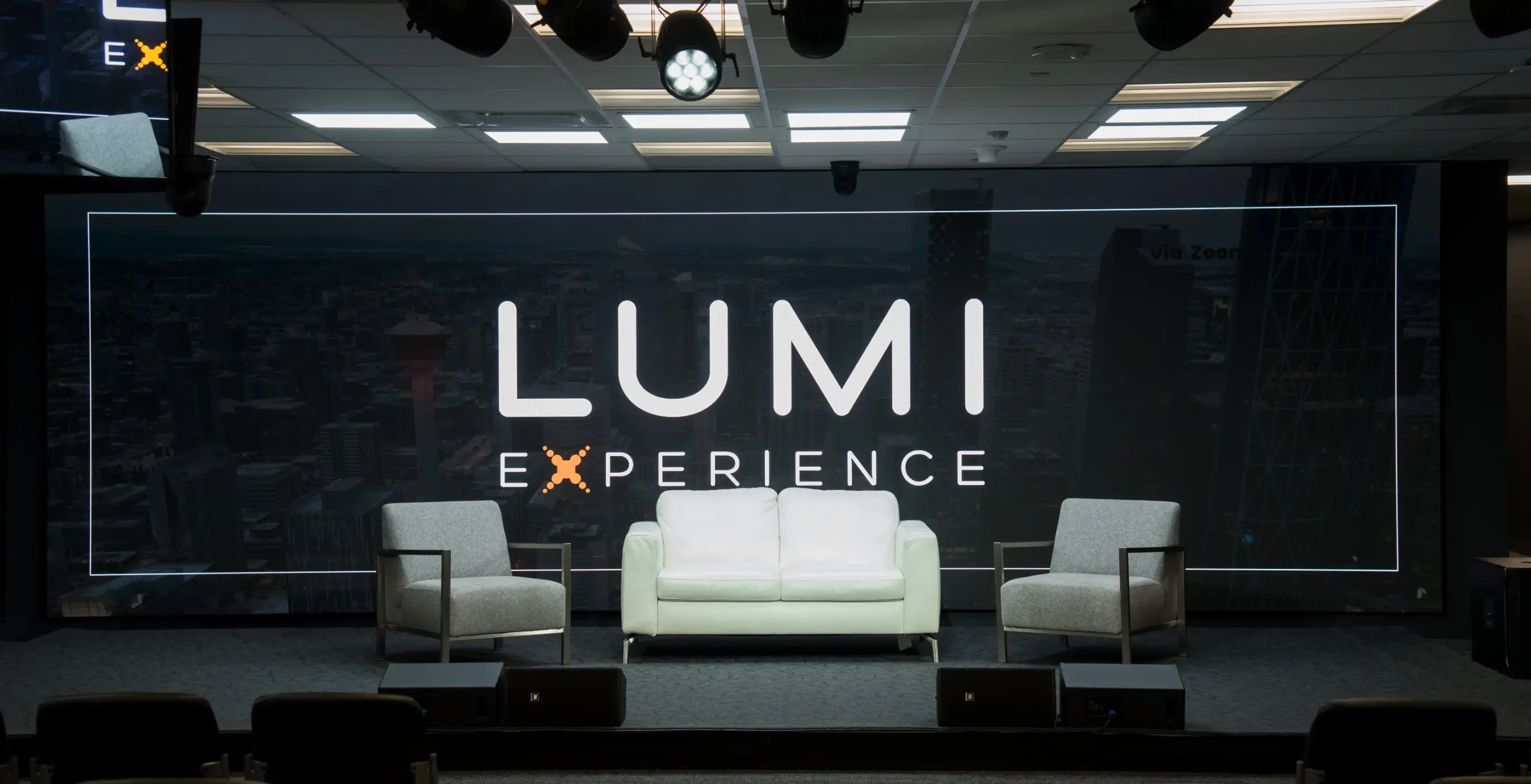 Sofa and 2 chairs in front of Lumi Experience screen